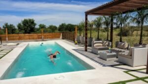 Piscina de fibra de vidrio Lagoon modelo 8350 (8x3,5 m) con personas nadando